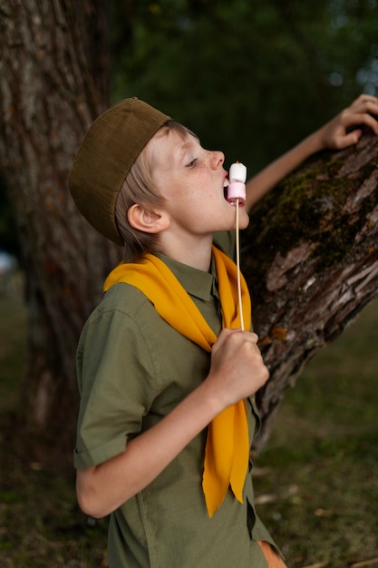 Foto gratuita bambino di vista laterale che mangia le caramelle gommosa e molle