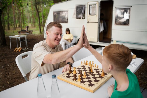 Side view kid and father playing chess