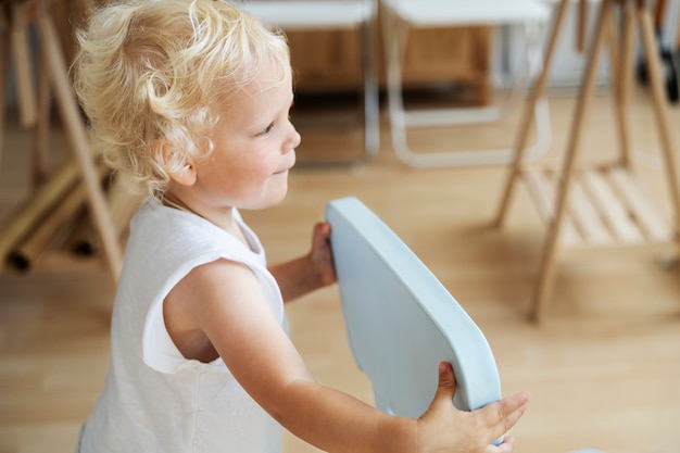 Side view kid holding chair