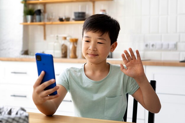 Side view kid holding smartphone