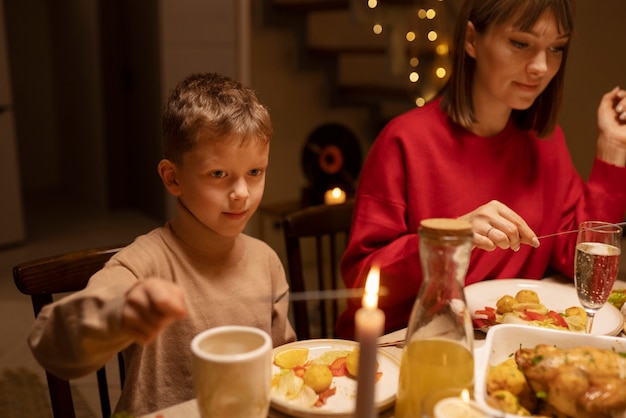 Free photo side view kid and mother at table