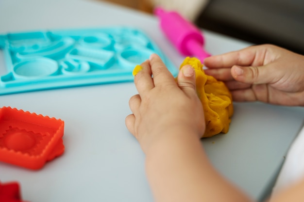 Side view kid playing with playdough