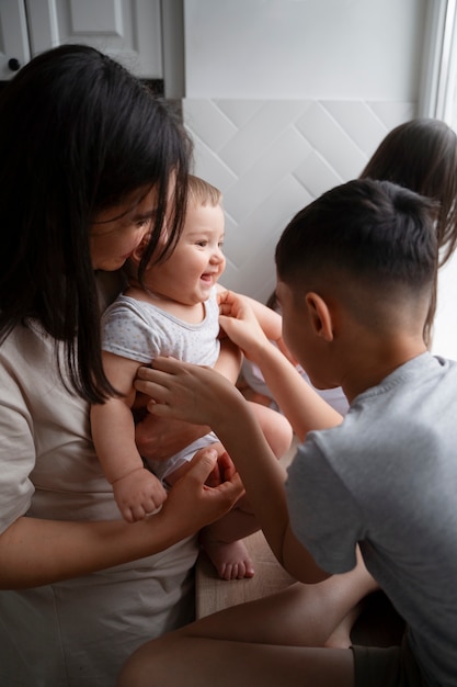 Free photo side view kid tickling baby