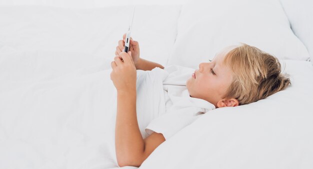 Side view kid watching something on a tablet 