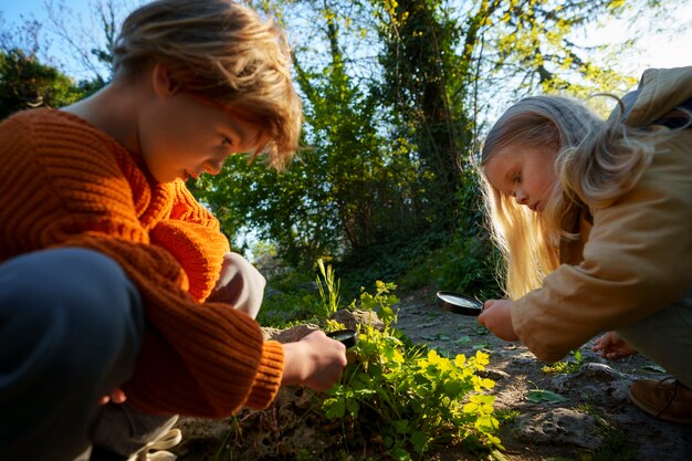 Вид сбоку дети вместе исследуют природу
