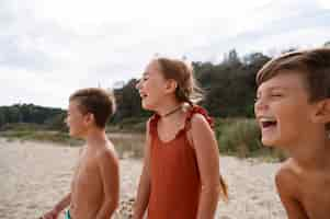 Foto gratuita bambini con vista laterale che si divertono in spiaggia