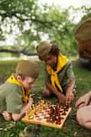 Free photo side view kids playing chess