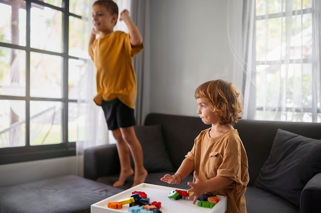 Free photo side view kids playing indoors