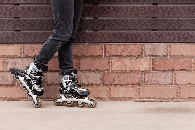 Side view of legs wearing roller blades with copy space