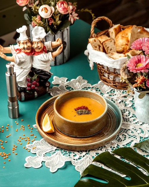 Side view of lentil merci soup in bowl with a slice of lemon