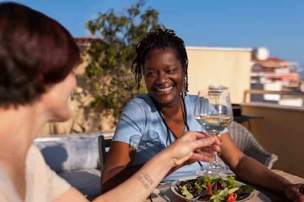 Free photo side view lesbian couple at restaurant