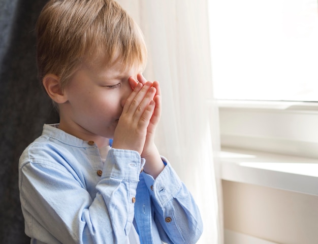 Side view of little boy praying