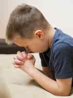 Free photo side view of little boy praying