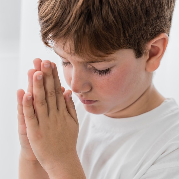 Side view of little boy praying