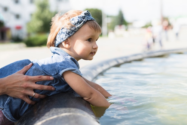 Free photo side view of little girl at fountain