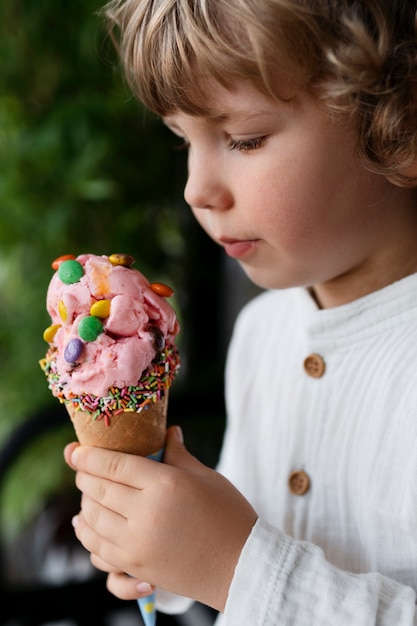 Foto gratuita bambino di vista laterale che tiene il gelato