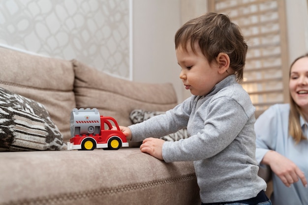 Side view little kid playing with car