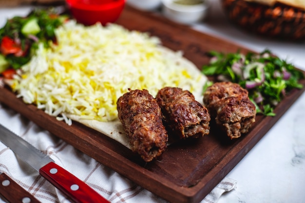 Free photo side view lula kebab with rice and onion