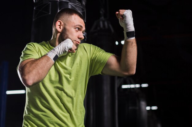 Side view of male boxer posing in the gym