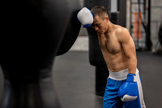 Free photo side view of male boxer resting after practice