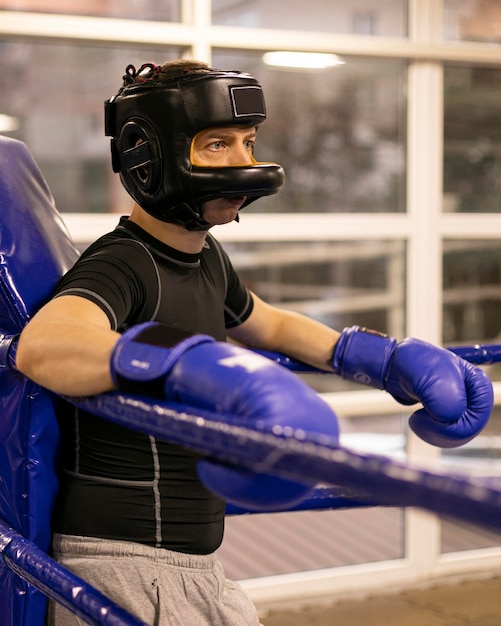 Free photo side view of male boxer with helmet