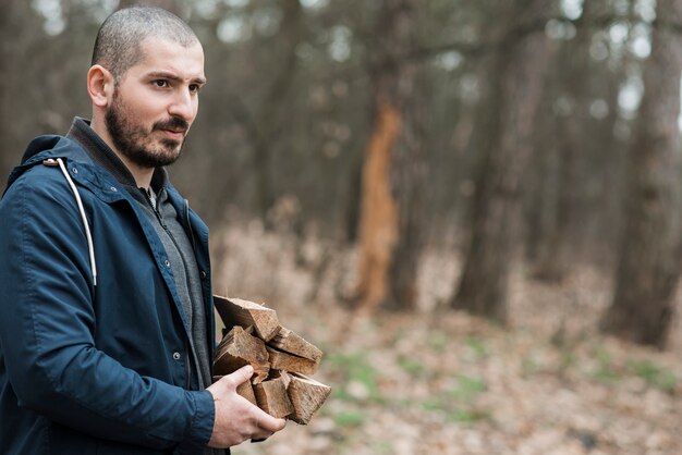 Free photo side view male carrying wood