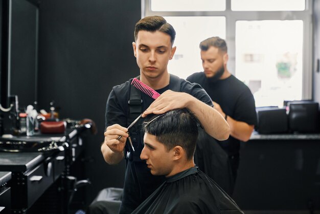 Side view of male client getting new haircut at barbershop