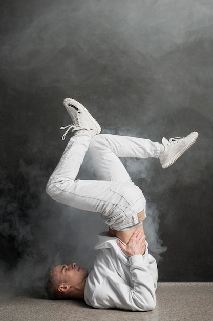 Вид сбоку танцор в позе танца с дымом
