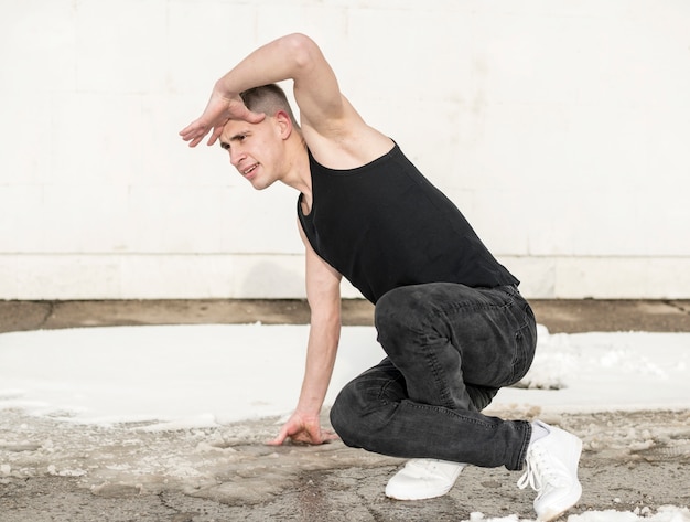 Vista laterale del ballerino maschio che posa mentre ballando