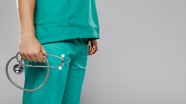 Side view of male doctor holding stethoscope with copy space