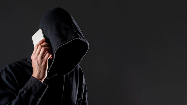 Вид сбоку мужской хакер разговаривает по смартфон с копией пространства