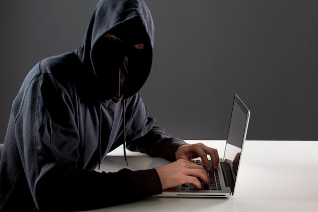 Вид сбоку мужской хакер с ноутбуком
