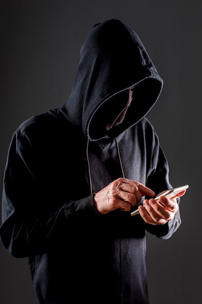Вид сбоку мужской хакер с смартфона
