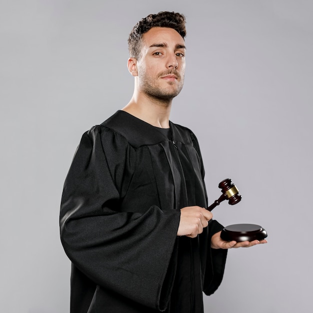 Free photo side view of male judge with gavel