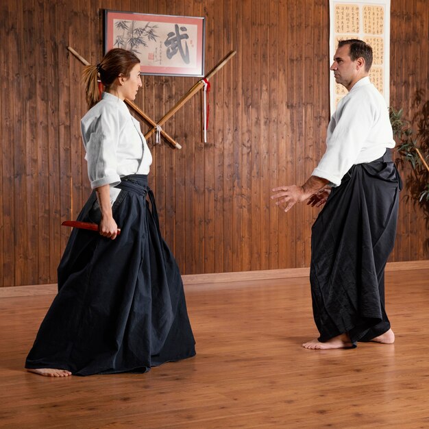 Side view of male martial arts instructor and female trainee in the practice hall