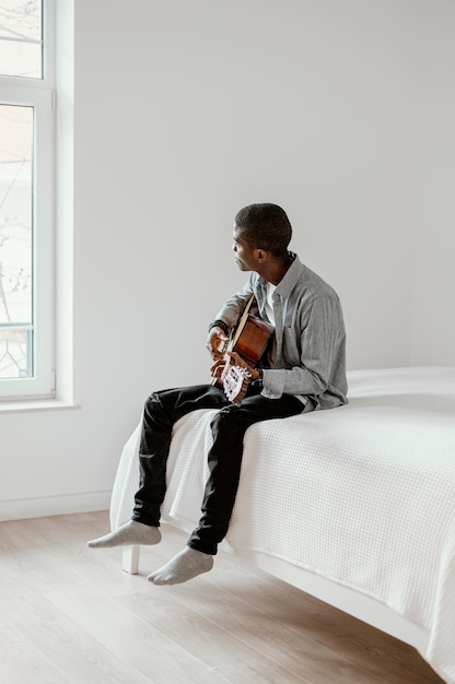 Side view of male musician with guitar