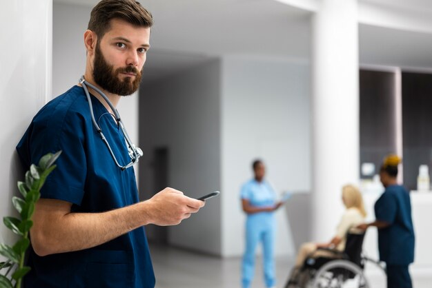 Side view male nurse holding smartphone