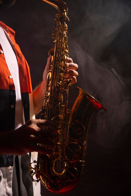 Side view of male playing the saxophone in the spotlight