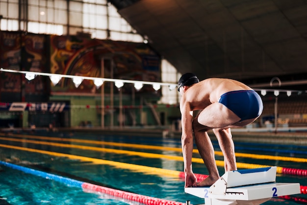 側面図の男性スイマーがレースの準備