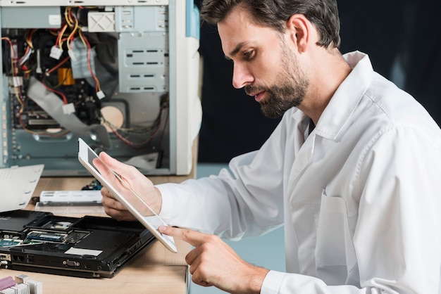 Vista laterale di un tecnico maschile utilizzando la tavoletta digitale