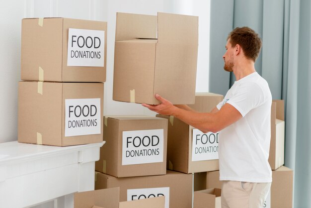 Side view of male volunteer preparing boxes with provisions