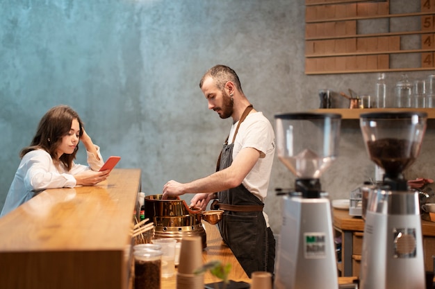 Side view of man in apron with customer