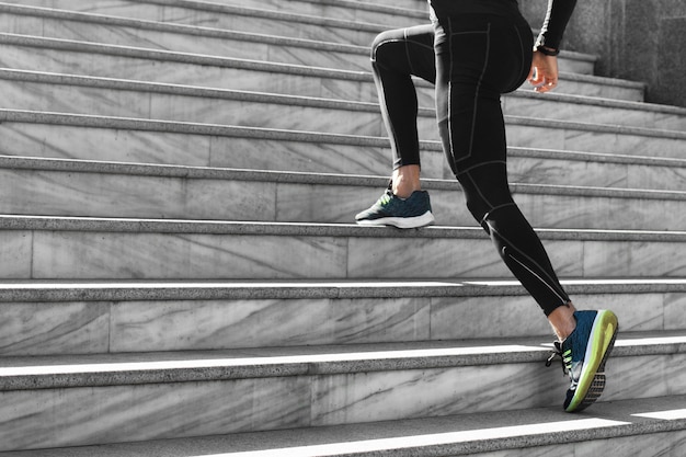 Side view of man in athletic wear exercising on stairs outdoors