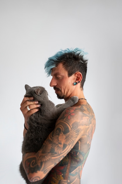 Free photo side view man being affectionate with cat