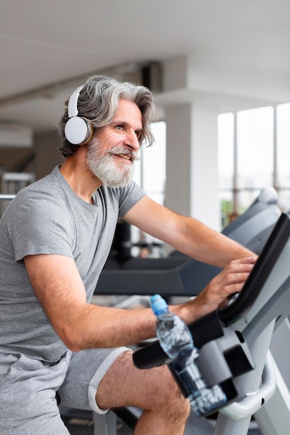 Free photo side view man on bicycle indoors