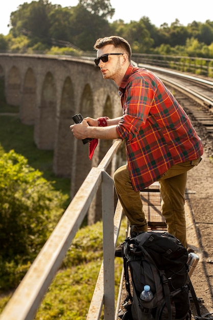 Side view man at bridge with binocular