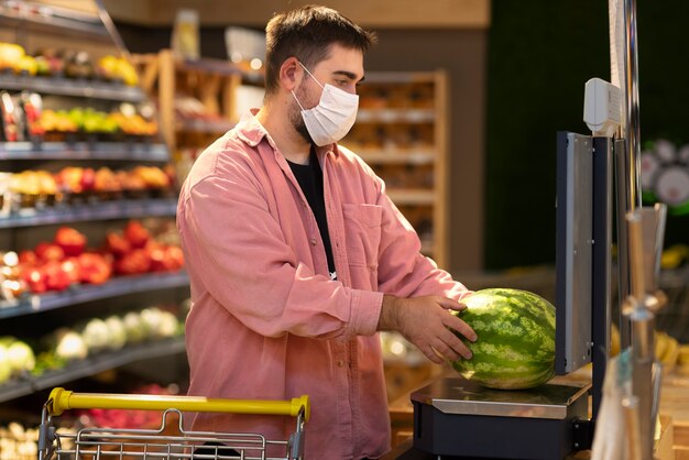 Side view man buying watermelon