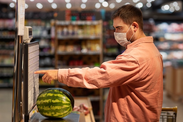 Side view man buying watermelon