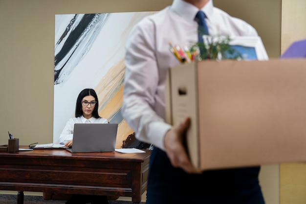 Free photo side view man carrying cardboard box