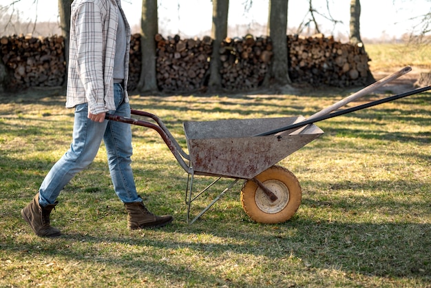 Side view man carrying wheelbarrow